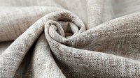 Natural beige linen fabric with soft texture and gentle folds, showcasing organic textile material for home decor, fashion design, and craft projects.