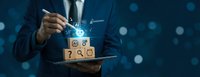 Businessman in suit holding tablet with wooden cubes featuring AI icons and glowing digital symbols on dark blue background.