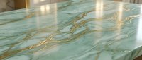 Luxurious green marble countertop with golden veining reflecting warm light in modern kitchen interior design for home renovation projects.