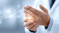 Professional hands cupped together with glowing light and sparkles, representing healing energy, spiritual wellness, and holistic healthcare concepts.