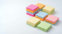 Colorful stacked sticky notes in pink, yellow, green, and blue arranged on white background, ready for office organization and memo design projects.