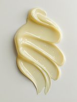 Creamy white cosmetic product smear texture showing smooth, swirled consistency against light background, isolated for beauty and skincare marketing materials.