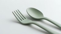 Sage green plastic fork and spoon set on white background, eco-friendly reusable cutlery for modern kitchen, dining, and food styling concepts.