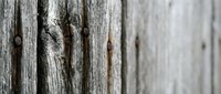 Weathered wooden fence planks with natural grain patterns and rustic texture, perfect for backgrounds and design projects.