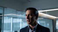 Confident middle-aged Caucasian businessman in suit with futuristic holographic UI interface overlay in modern office, technology innovation concept.