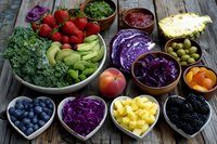 Colorful antioxidant-rich superfoods arranged in heart-shaped bowls on rustic wooden table featuring fresh berries, vegetables and healthy ingredients.