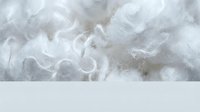 Close-up of white fluffy fibers and soft textile material, suitable for backgrounds, wellness content, comfort product marketing, and fabric industry applications.