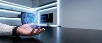 Businessman holding glowing digital brain hologram on desk in modern office, representing artificial intelligence, technology innovation, and future computing solutions.