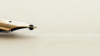 Elegant fountain pen nib on textured paper background for luxury writing, calligraphy, business correspondence and professional documentation concepts.