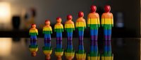 Rainbow colored human figures standing in row representing diversity, inclusion and LGBTQ pride community support with reflective surface background.