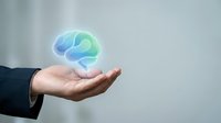 Businessman hand holding glowing holographic brain icon representing artificial intelligence, innovation and mental health concepts for corporate presentations.