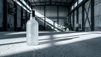 White frosted glass bottle mockup in industrial warehouse setting with dramatic lighting and concrete floors for product presentation and branding design.