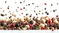 Mixed peppercorns scattered and falling with pink, black, white, and green varieties creating dynamic composition against white background for culinary design.