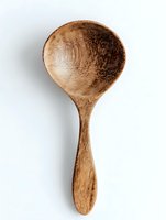 Handcrafted wooden spoon isolated on white background, showcasing natural grain texture and rustic design for eco-friendly kitchen utensils.