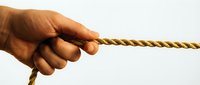 Hand gripping thick golden rope against white background showing strength determination and pulling motion for teamwork leadership concepts.