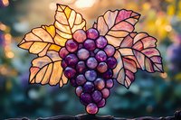 Stained glass grape bunch with autumn leaves glowing in sunlight against blurred bokeh background, artistic craft decoration for wine themes and harvest season.