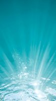 Underwater view of sunlight rays penetrating through turquoise water with bubbles and ripples, ideal for wellness, spa, and aquatic design projects.