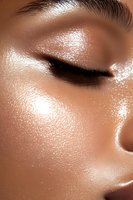 Close-up of glowing, dewy skin with shimmering highlighter effect and precise black eyeliner, showcasing modern beauty and skincare trends in cosmetics industry.