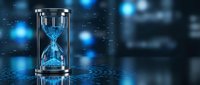 Glowing hourglass with blue sand flowing through glass timer on reflective surface against bokeh lights background for time management concepts.