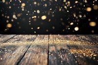 Golden glitter scattered on rustic wooden surface with magical bokeh lights floating in dark background, creating dreamy festive atmosphere.