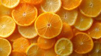 Fresh juicy orange slices arranged in rows creating vibrant pattern background with natural texture and bright citrus color for healthy food concept.