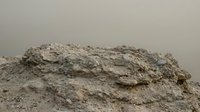Large pile of brown construction sand and gravel aggregate material for building projects and landscaping work on neutral background.