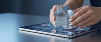 Hands holding transparent glass house model over digital tablet with real estate app interface for property investment and smart home technology.