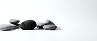 Smooth and textured stones arranged in a minimalist composition on white background, suitable for wellness, spa, meditation, and zen design projects.
