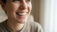 Young woman with metal braces smiling happily showing orthodontic treatment progress in dental care concept for healthcare and teeth straightening.