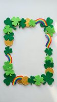 Festive St. Patrick's Day frame with shamrocks, gold coins and rainbows on white background for holiday greeting cards and party invitations.