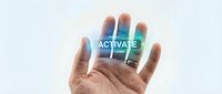 Hand holding glowing blue activate button in palm against light background for digital technology and user interface concepts.