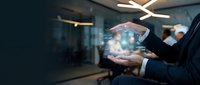 Professional businessman holding glowing digital hologram sphere in modern office environment showcasing futuristic technology and innovation concepts.