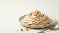 Creamy peanut butter mousse swirl served on white plate with spoon and crumbs, ready for dessert recipes and food styling projects.