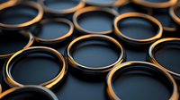 Macro view of black camera lens filters with golden edges arranged in rows creating abstract geometric pattern with selective focus and dark background.