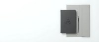 Minimalist black and gray notebooks with silver pen on white background. Clean office supplies for business branding and corporate identity design projects.