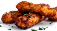 Golden crispy chicken croquettes with herbs on white background, ready-to-eat appetizers for restaurant menus and food photography projects.
