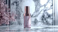 Pink marble cosmetic bottle on reflective surface against marble background with cherry blossom decoration, luxury skincare product photography.