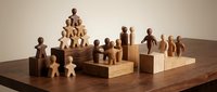 Wooden toy figures arranged on blocks showcasing teamwork and leadership concepts for business presentations and educational materials.