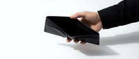 Hands holding modern black smartphone with blank screen on white background, isolated for mobile app mockup and digital technology presentations.
