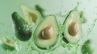 Fresh avocado halves with pits surrounded by green juice splash on light background, showcasing healthy organic food for nutritional content.