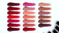 Colorful lipstick swatches in various shades from deep burgundy to nude pink arranged in rows on white background for cosmetic testing and color selection.