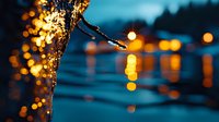 Glowing water droplets on glass with blurred city lights creating magical bokeh effect at dusk, moody atmospheric evening scene in blue and gold tones.