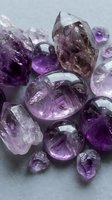 Natural amethyst crystals and gemstones in various shapes and sizes displaying rich purple hues for jewelry making, healing practices, and decorative purposes.