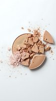Broken face powder compact with scattered makeup dust on white background for beauty and cosmetics advertising.