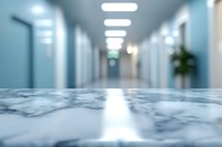 Modern hospital corridor with marble surface in foreground, blurred medical facility background with fluorescent lighting and clean white walls.