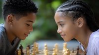 African American boy and girl playing chess outdoors, focused on strategic game with natural green background, showing youth learning and concentration.