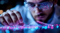 Young male scientist in protective eyewear examining glowing neon pink and blue particles in dark laboratory setting, demonstrating advanced research and innovation in science.