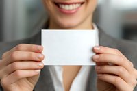 Smiling businesswoman holding blank white card, perfect for adding your message or logo for corporate branding or business communication.