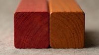 Two wooden blocks with natural grain patterns in warm red and orange tones, showcasing timber texture and craftsmanship for construction and woodworking projects.