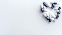 Heart shape made from blue and white medical capsules and pills on light background with copy space for healthcare and pharmacy concept.